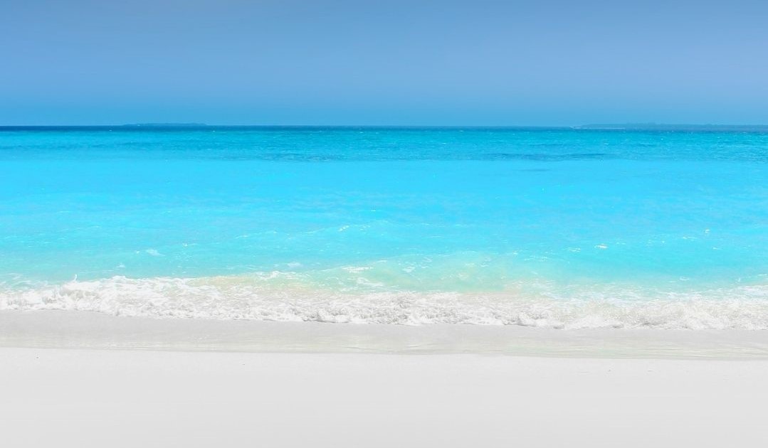 Looking out into a blue ocean from a beach