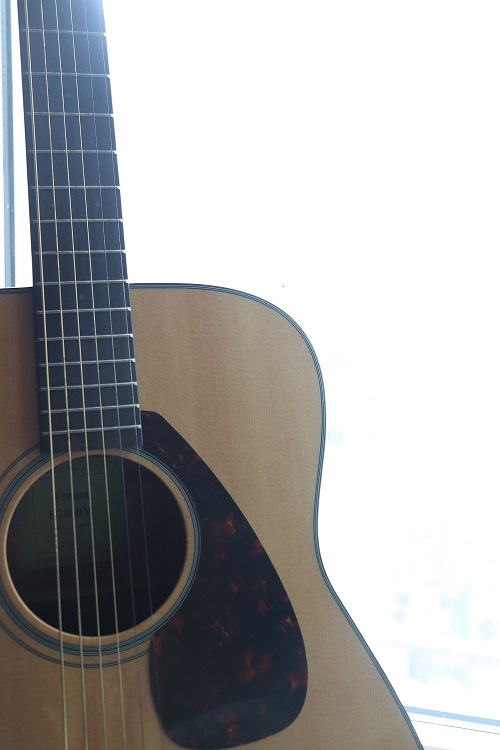 Acoustic guitar in front of a window