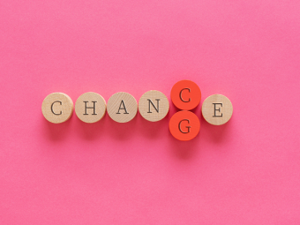 Photo of wooden pegs spelling change/chance with pink background and text 