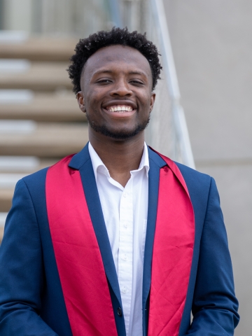 Photo of O Omodior standing outside with stairway 