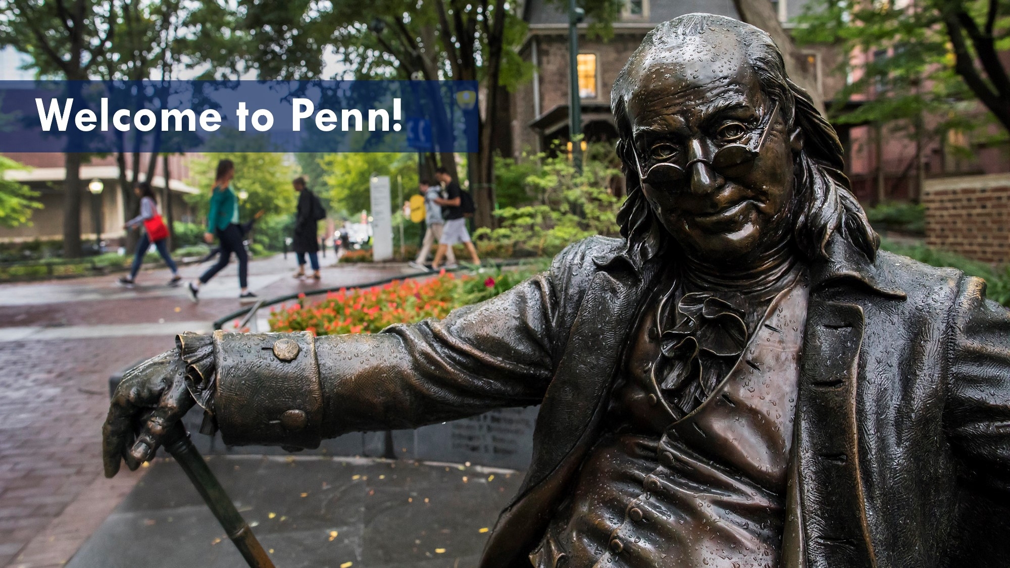 Photo of seated Ben Franklin statute with Locust Walk in background